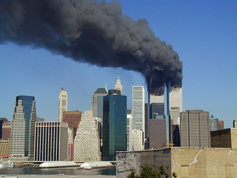 写真は、2001年9月11日の朝、2機の飛行機が突入した直後の世界貿易センタービル。 両ビルからは黒くて厚い煙が立ち上っている。